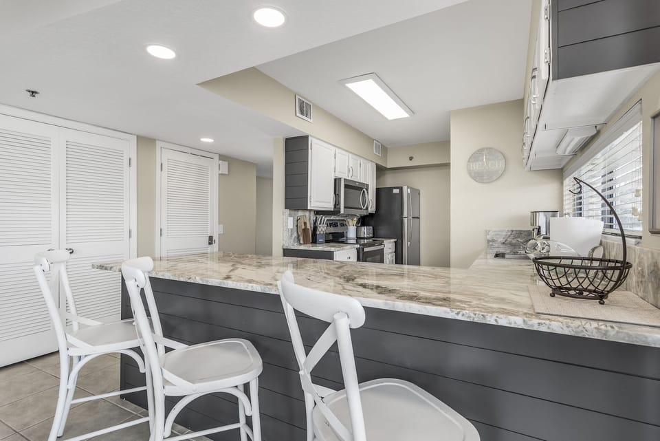 Your fully equipped kitchen features stunning marble counters, stainless steel appliances, and stylish bar seating for casual dining.