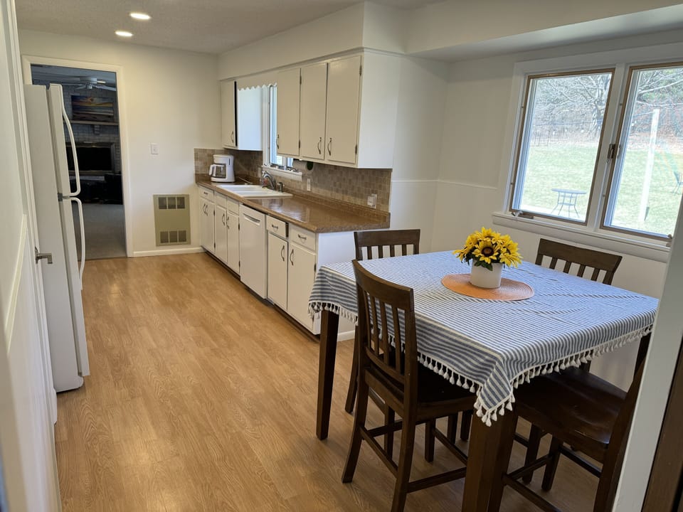 Fully equipped kitchen with high top table with 4 chairs. Opening to living area
