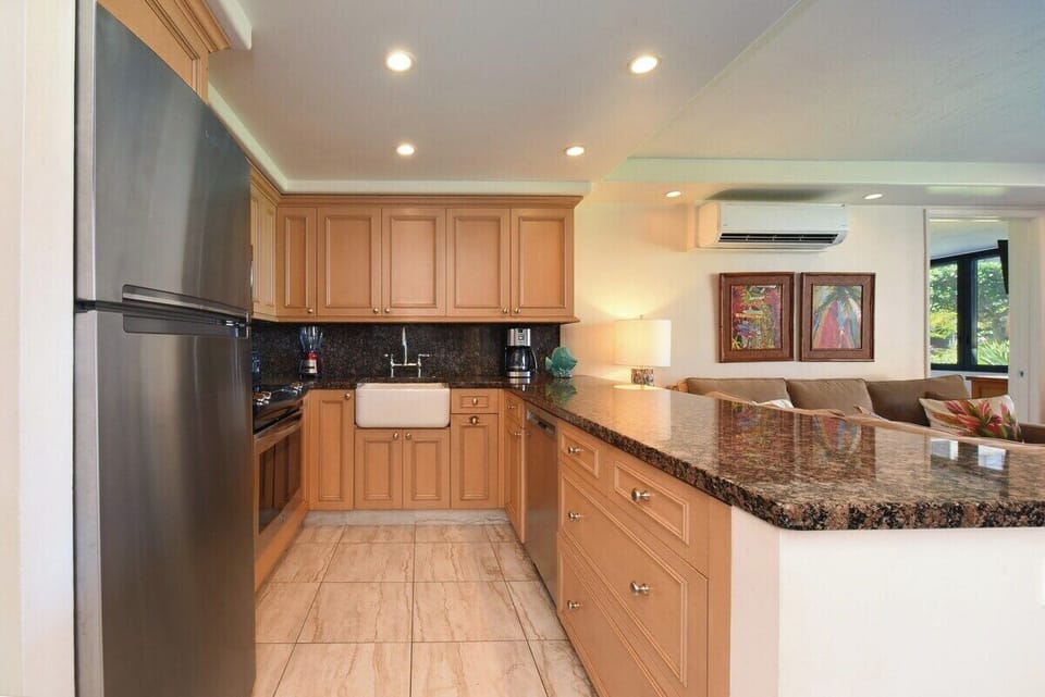 Gather at farmhouse sinks where island light pours in.