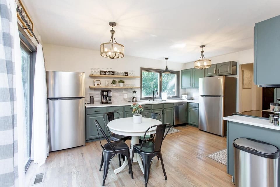 The kitchen is on the main level of the home and has Quartz countertops, tile backsplash, SS appliances and eat-in dining area