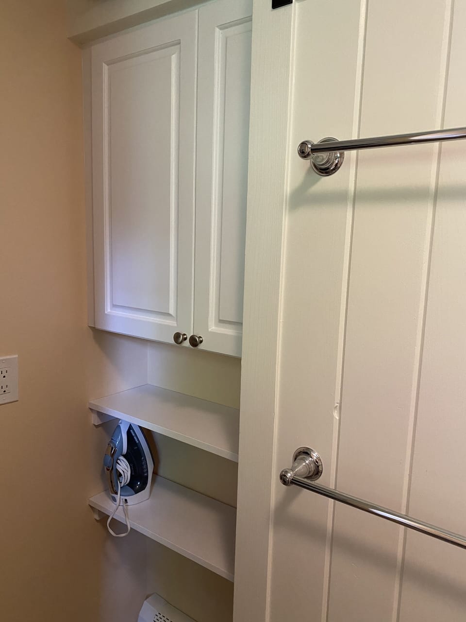 Storage area for supplies behind sliding barn door with towel racks