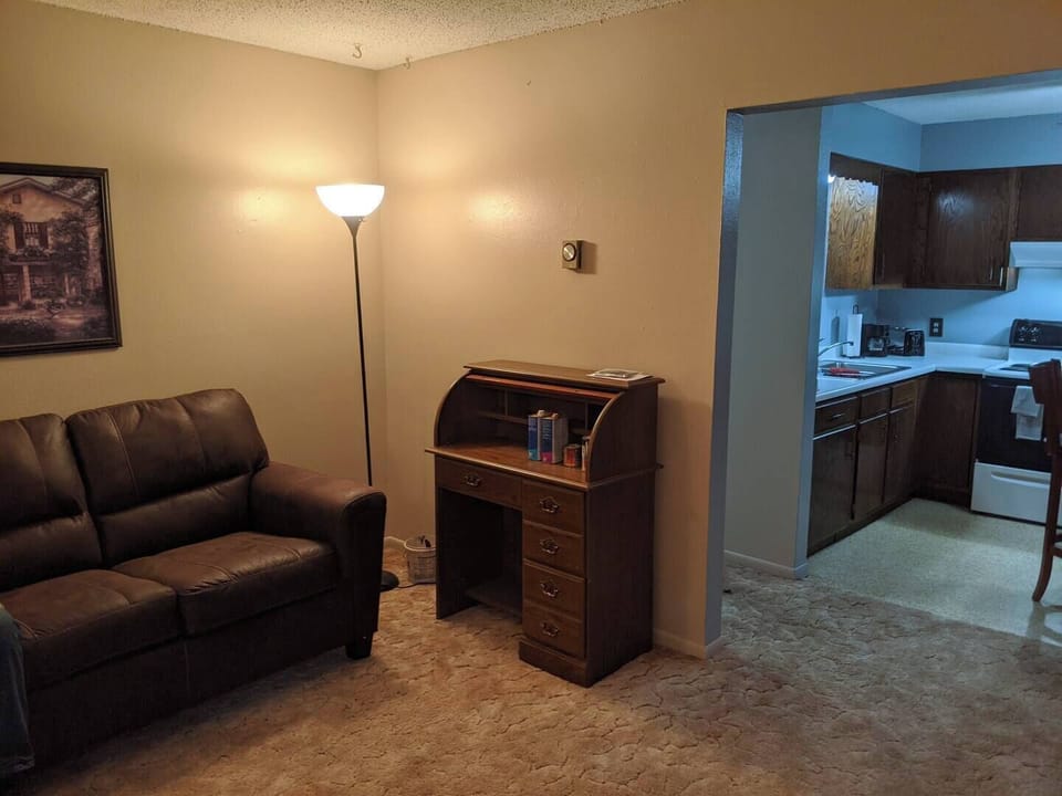 Living room with view of kitchen and hallway to the bedrooms and bathroom