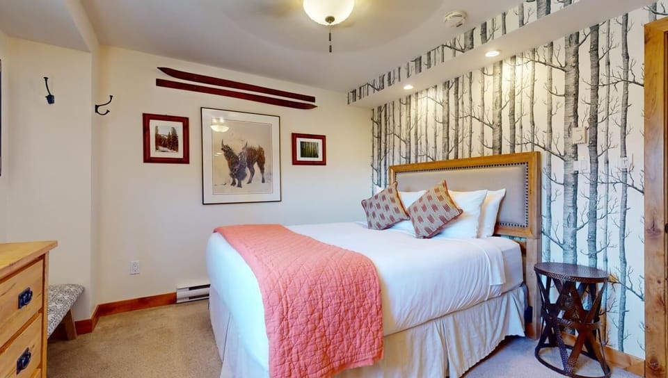 Sink into your plush bed dressed in soft linens and a cozy coral throw. The birch forest accent wall creates a tranquil retreat, perfect for restful nights after your adventures.