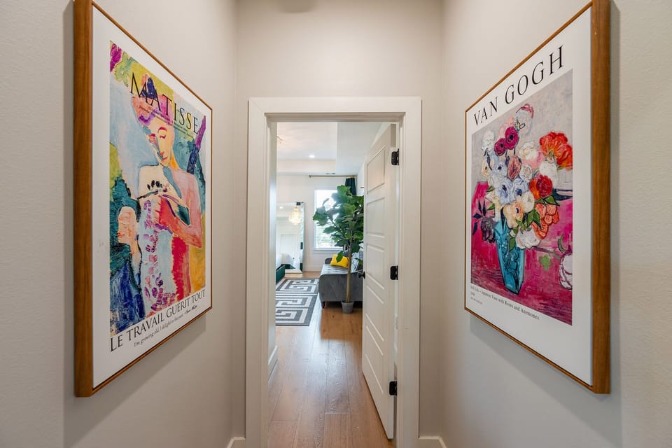 Bright art-lined hallway leading to a stylish, light-filled living space