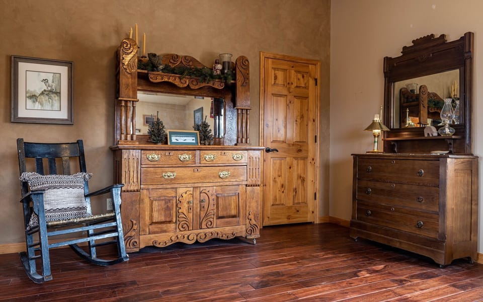 The primary bedroom suite is full of unique furniture and charm