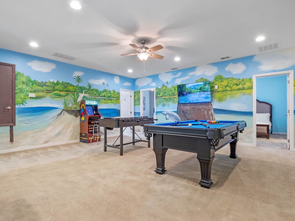 - Game room with pool table, foosball, and arcade fun  
- Wall mural adds vibrant theme park inspired vibes  
- Entertainment filled Orlando vacation rental house