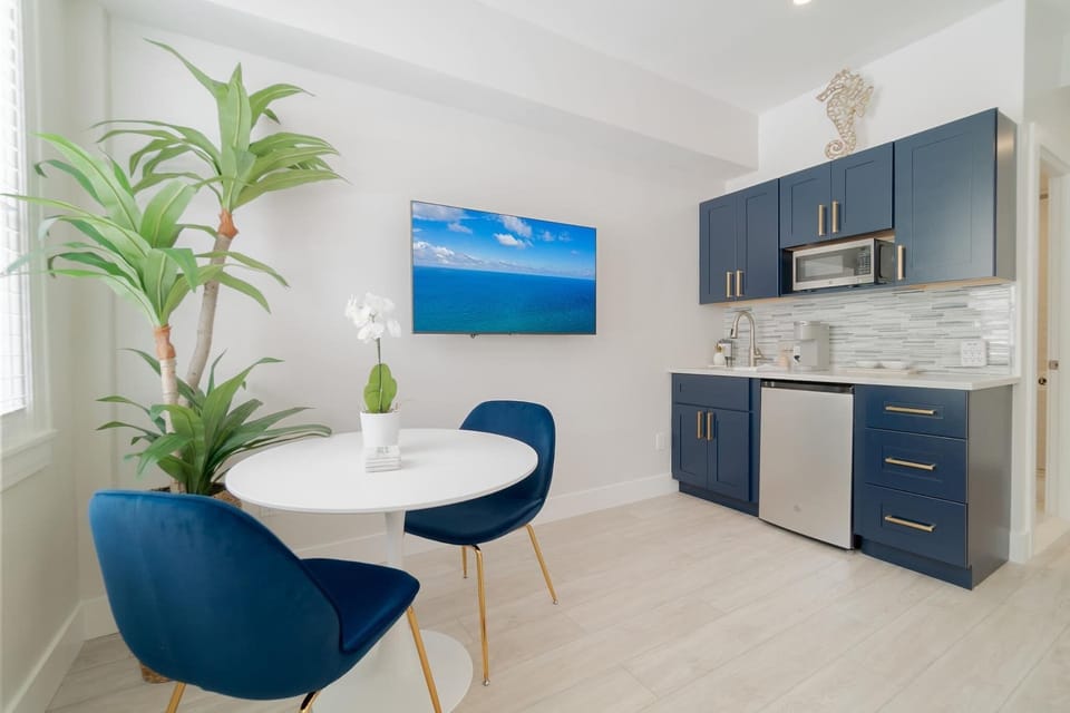 Sitting area for dining and work space. 
Kitchenette with microwave, mini fridge, Keurig coffee maker, glasses, plates, and cutlery
