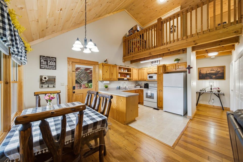 Family dining for 4 at the log table, with views of the barn and hayfield.