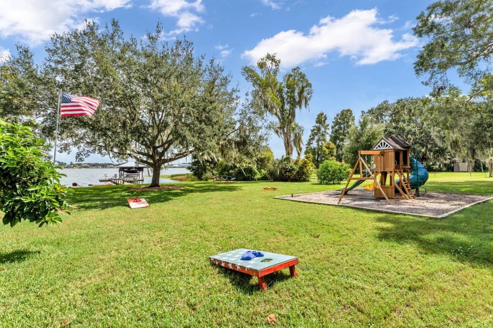 Spacious lakefront backyard with play area, open lawn, and scenic water views.