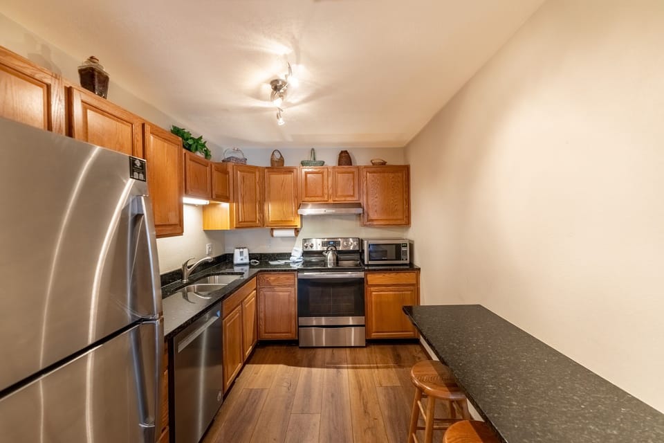Your fully equipped kitchen features granite countertops, stainless steel appliances, and rich wood cabinets—perfect for preparing meals during your stay.