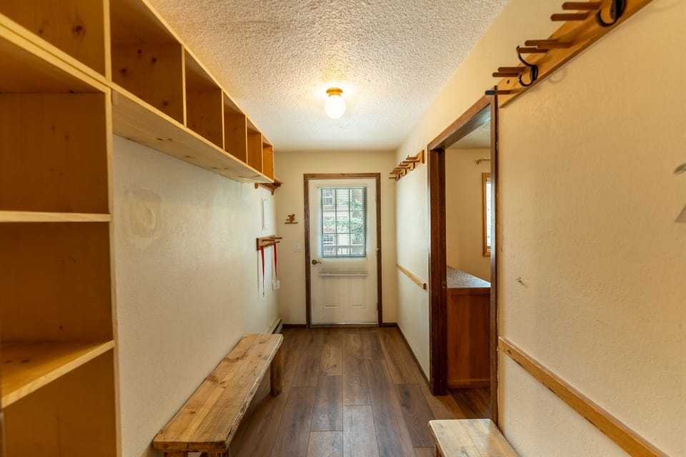 Your private mudroom welcomes you with custom cubbies and rustic bench—perfect for storing gear after mountain adventures.