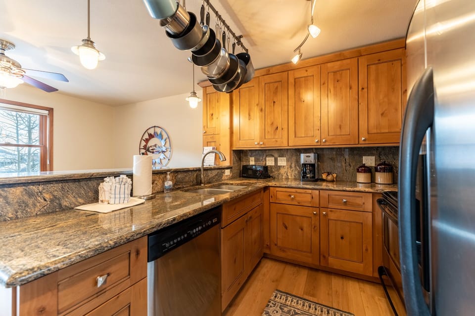 Your fully equipped kitchen awaits with granite counters, stainless appliances, and warm wood cabinets for memorable meal prep.