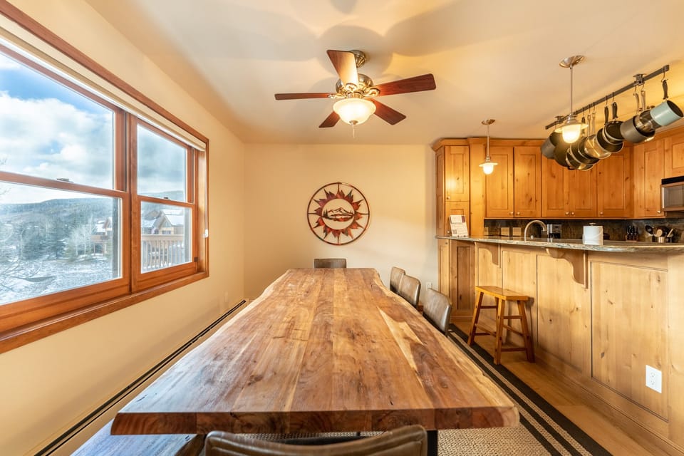 Gather around your rustic wooden dining table with mountain views streaming through large windows, perfect for meals and memories.