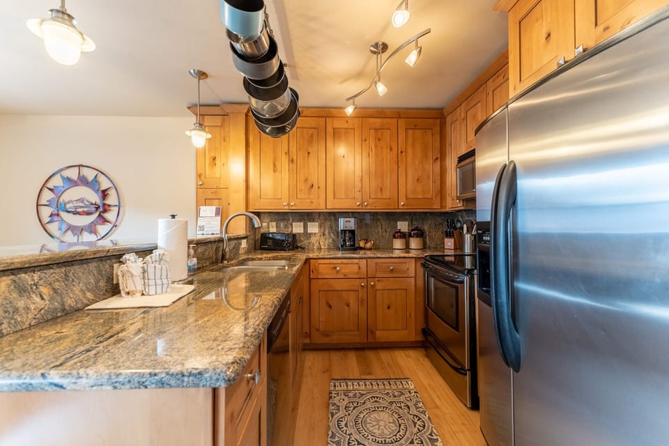 Your fully-equipped kitchen awaits with granite counters, stainless steel appliances, and warm wood cabinets—perfect for creating memorable meals together.