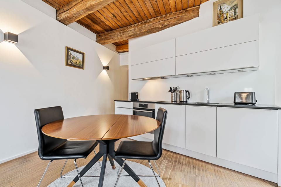 Cozy dining area with a modern table and chairs, adjacent to a fully equipped kitchen for a home-like experience.