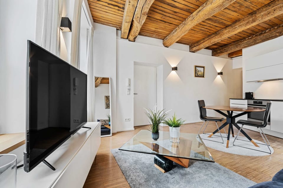 Spacious and modern living area with a large TV, perfect for relaxation and entertainment.