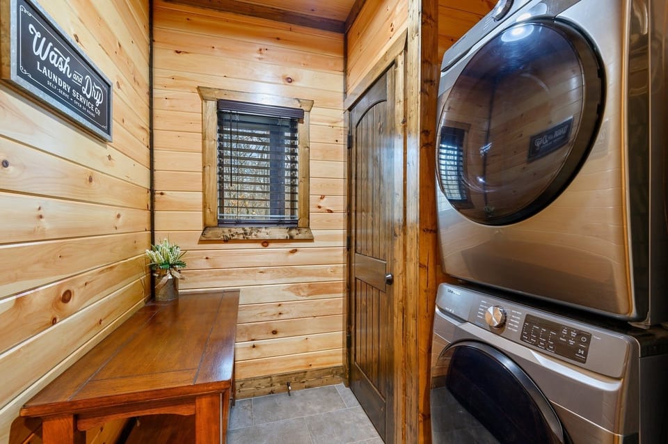 Laundry room with full size stacked washer and dryer. Iron and ironing board. 