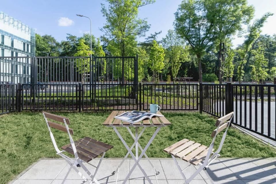 An outdoor space with a green lawn, deck chairs, and a fence, providing a peaceful area for relaxation.
