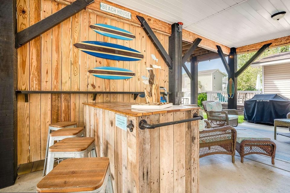 Rustic outdoor bar with surfboard decor and cozy seating
