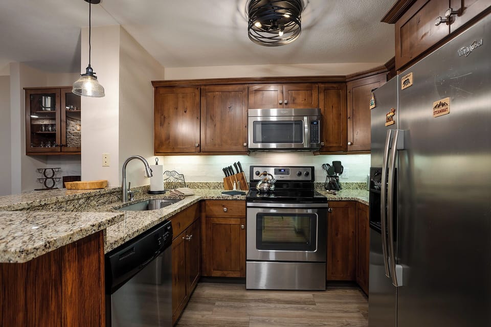 Your fully equipped kitchen features warm wood cabinets, granite countertops, and stainless steel appliances for memorable cooking experiences.
