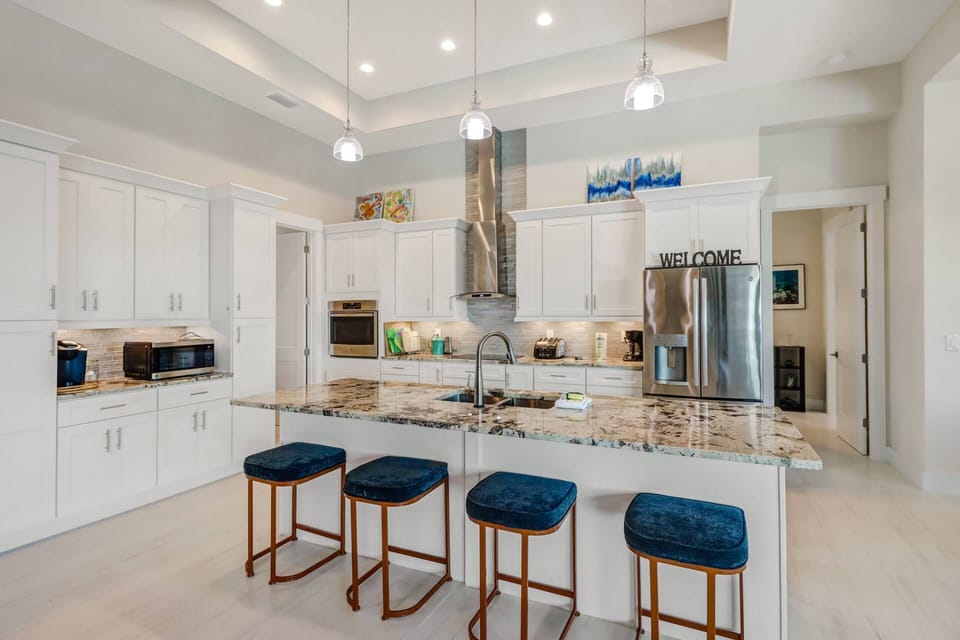A large island separates the well-equiped, show-piece kitchen from the open great room.