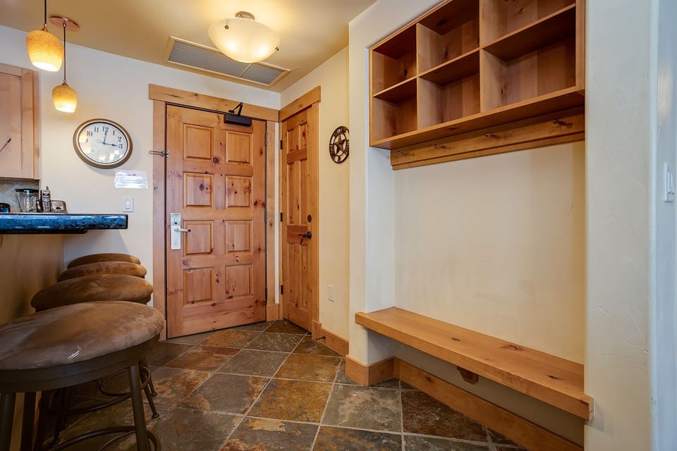 Your mudroom welcomes you with warm wood storage cubbies and a cozy bench—perfect for organizing gear after mountain adventures.