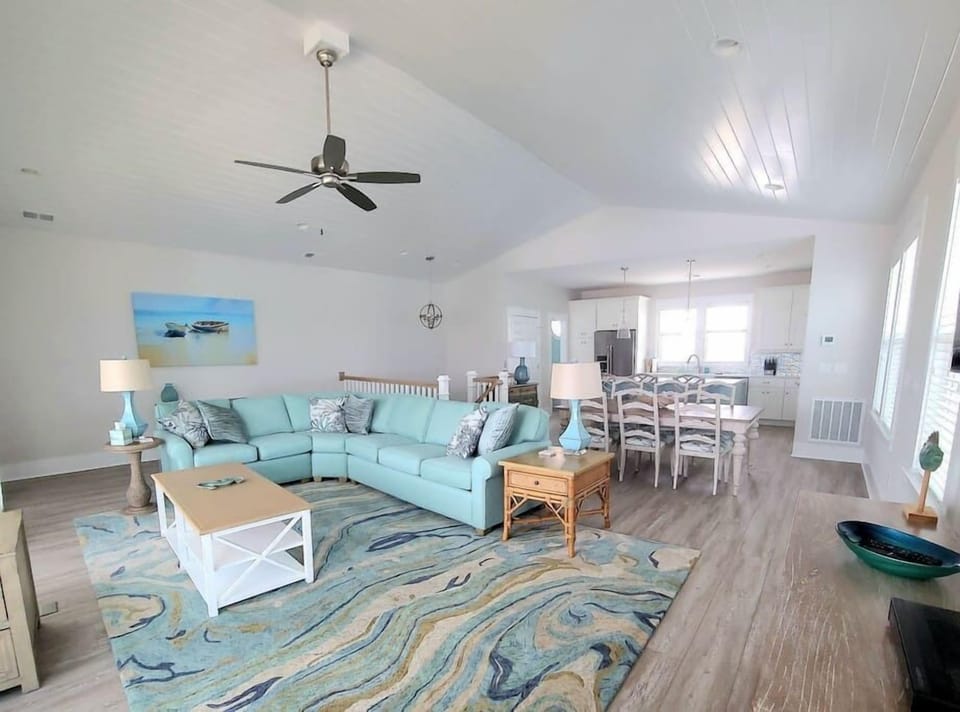 Bright and sunny living room with open kitchen and dining room concept.  Vaulted ceilings. 