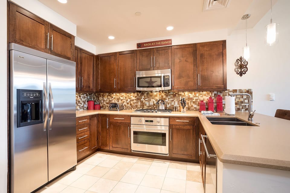 Your fully-equipped kitchen features stainless steel appliances, warm wood cabinetry, and granite countertops for preparing memorable meals during your stay.