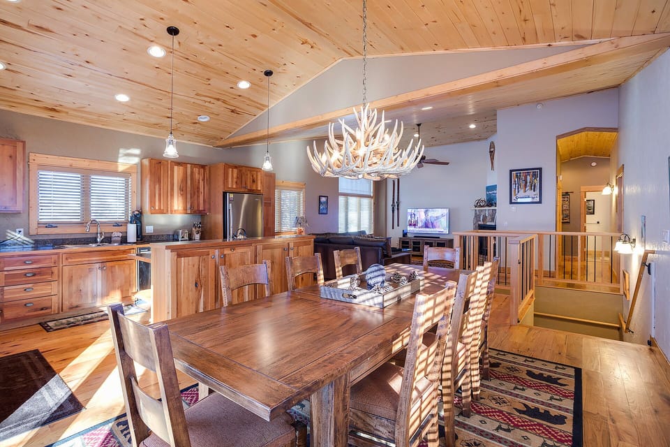 You'll love gathering around this rustic dining table under the stunning antler chandelier, with the open kitchen perfect for cooking together.