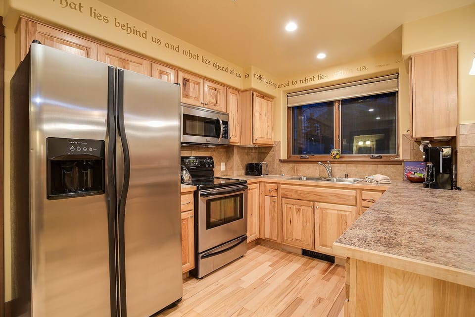 Cook your favorite meals in this fully-equipped kitchen with granite countertops, stainless steel appliances, and warm wood cabinets.