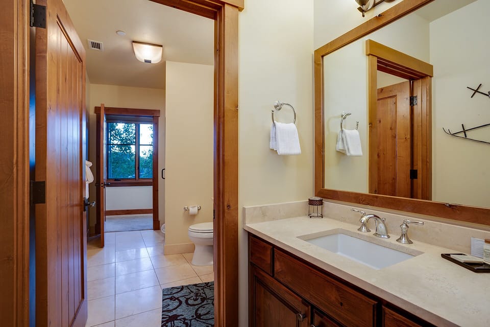 Your private bathroom features warm wood accents, elegant marble counters, and plush towels—everything you need to start your day feeling refreshed and at home.