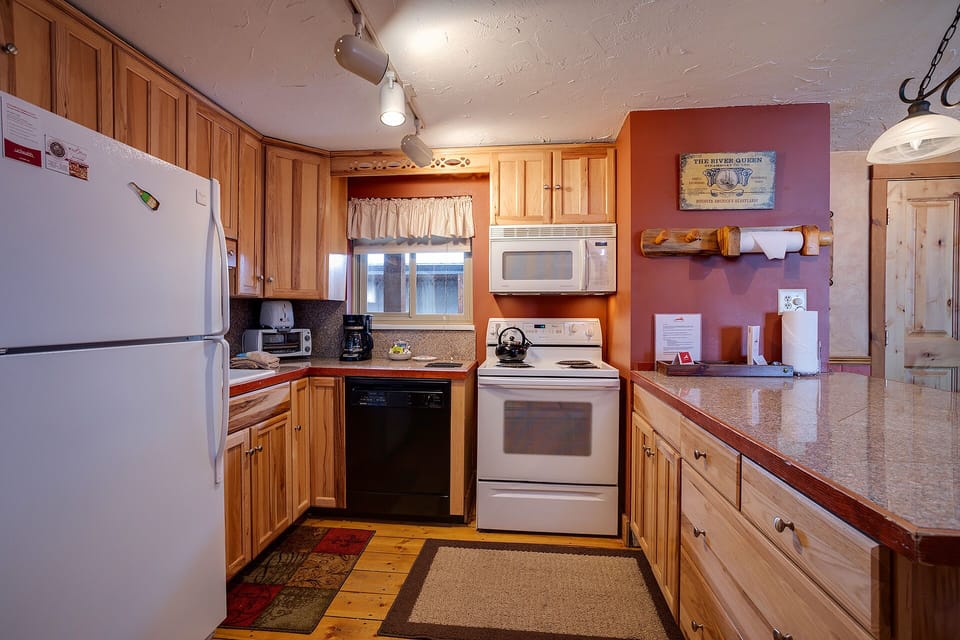 You'll love preparing meals in this fully equipped kitchen with warm wood cabinetry, full-size appliances, and ample counter space for cooking and gathering together.