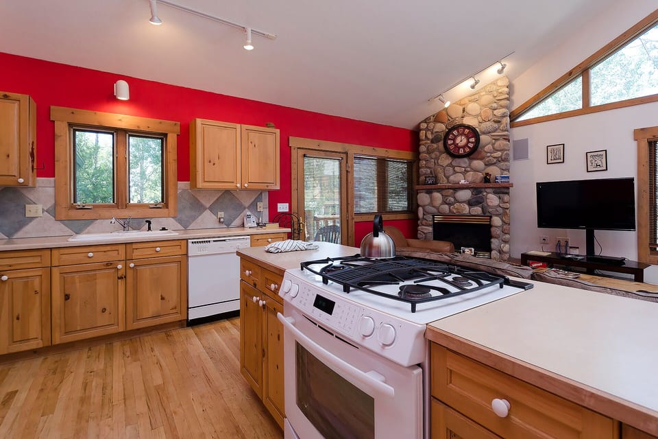 Cook memorable meals in your spacious kitchen featuring rich wood cabinets, granite counters, and a stunning stone fireplace backdrop for cozy evenings.