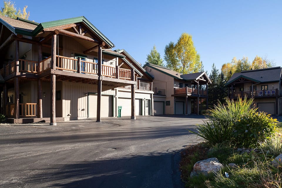 Mountain lodge-style buildings surrounded by autumn foliage create a charming retreat atmosphere in this peaceful location.