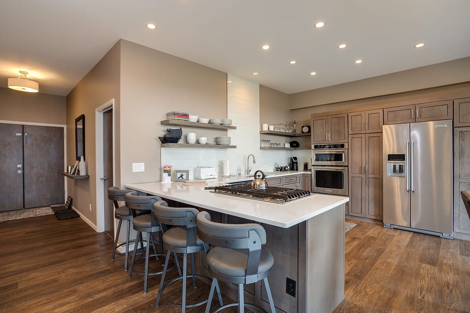 Cook gourmet meals in this sleek modern kitchen featuring quartz countertops, stainless appliances, and a spacious island perfect for entertaining.