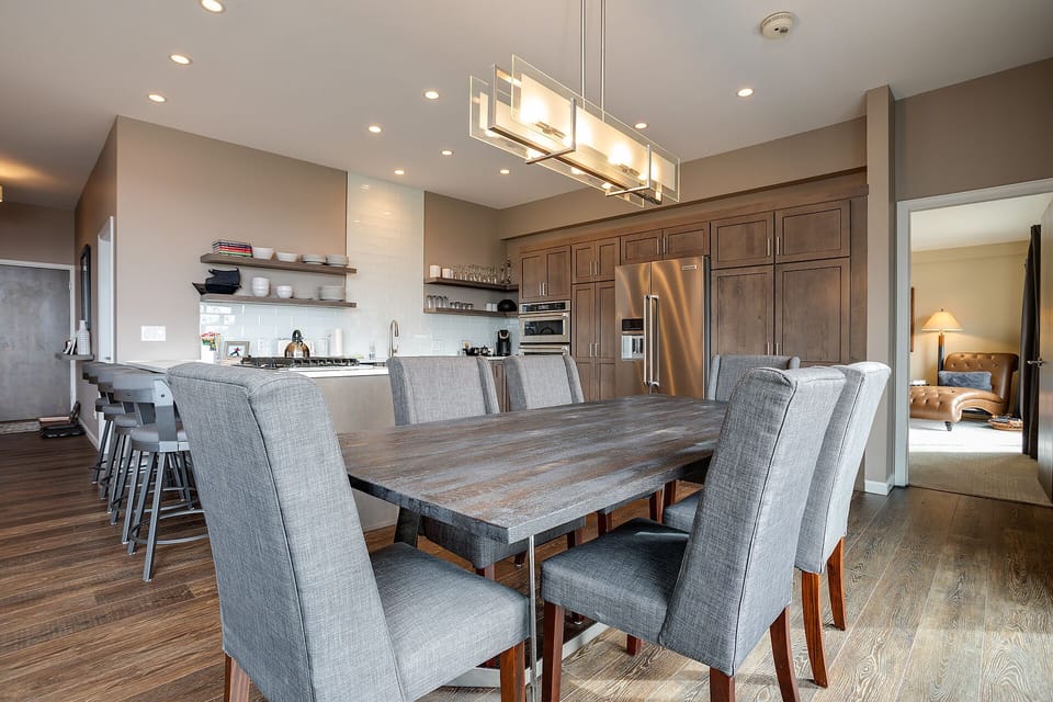 Gather around the elegant dining table where memorable meals await, perfectly positioned between your gourmet kitchen and cozy living spaces.