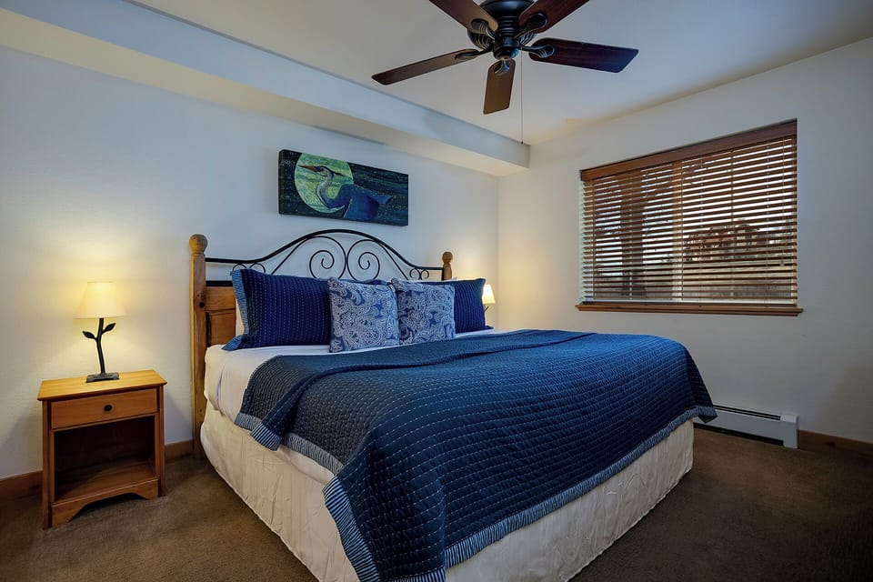 Unwind in your cozy bedroom, where crisp linens and soothing blue tones invite restful sleep. The soft glow of bedside lamps and gentle ceiling fan create the perfect atmosphere for relaxation.