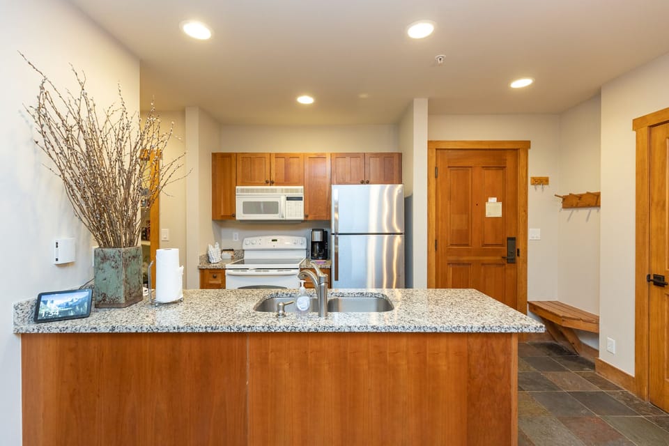 Your fully equipped kitchen features granite countertops, stainless appliances, and thoughtful touches like fresh branches that make cooking feel like home.