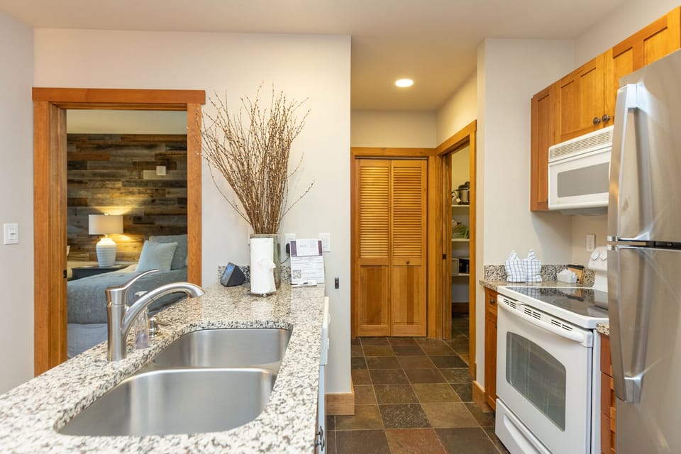 Your fully equipped kitchen features granite counters, stainless appliances, and flows seamlessly into your cozy living space.
