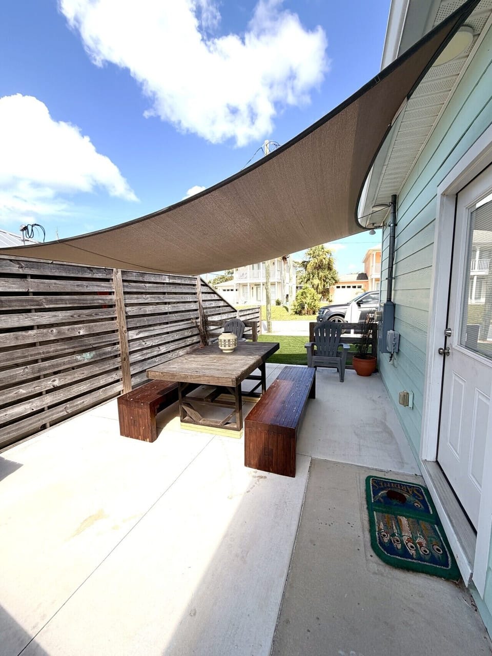 Side porch with seating, box with beach items, and outdoor shower