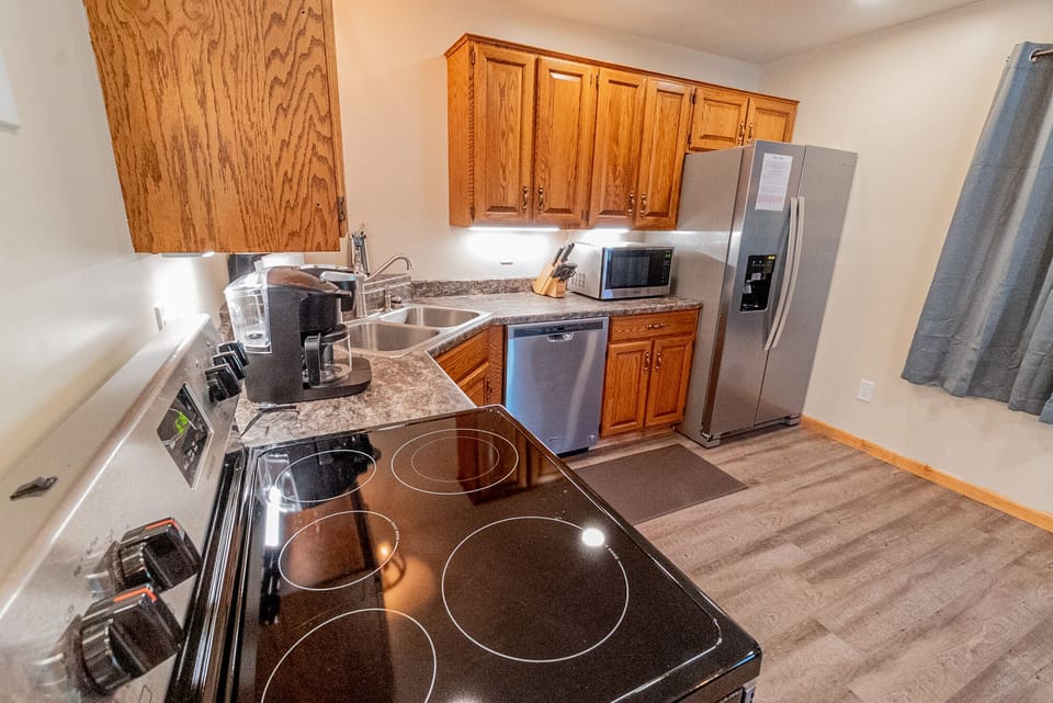 Kitchen - Main Level. Modern kitchen with conductive stove, dishwasher and modern refrigerator.