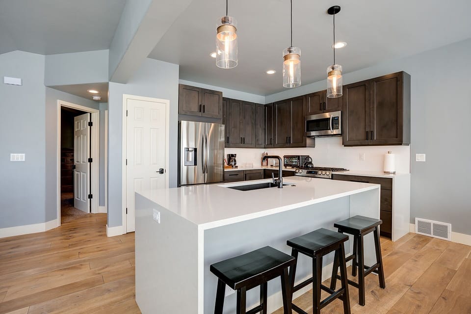Your fully equipped kitchen features sleek countertops, stainless steel appliances, and a breakfast bar where you can enjoy morning coffee.