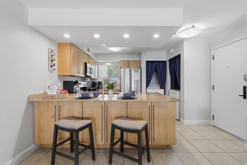 Fully equipped kitchen with breakfast bar seating — open-concept layout makes cooking and gathering easy during your stay.