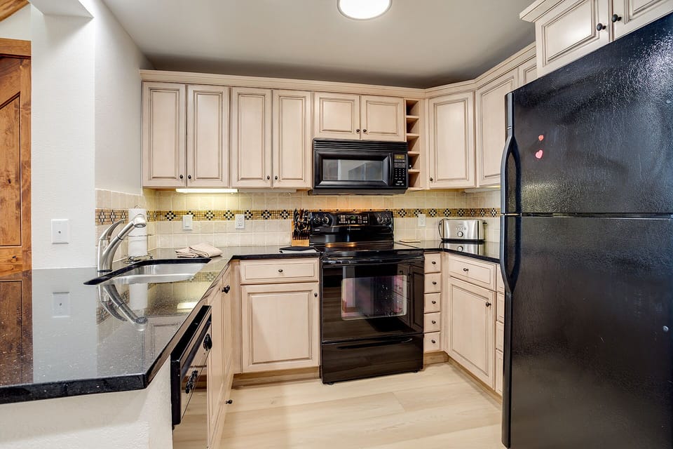 Cook your favorite meals in this well-equipped kitchen featuring granite countertops, stainless appliances, and ample cabinet storage.