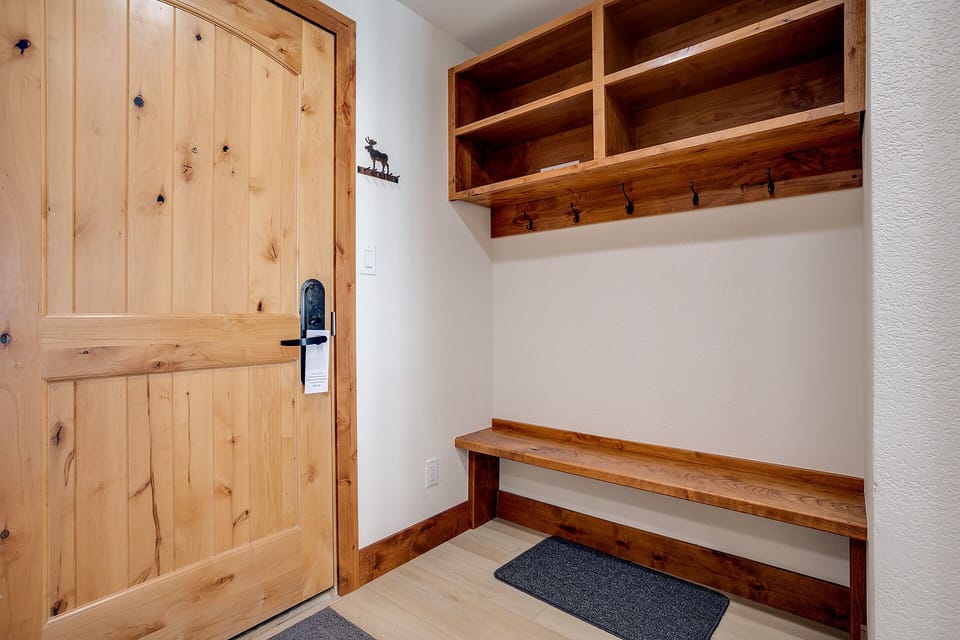 Your private mudroom welcomes you with handcrafted wooden storage, perfect for organizing gear after mountain adventures.