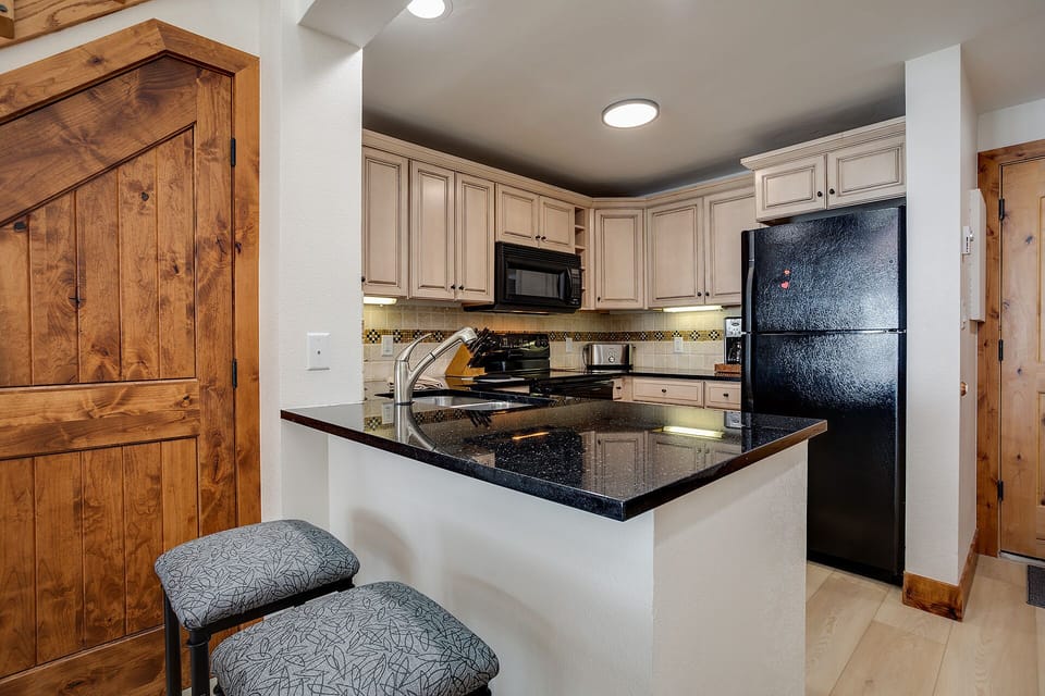 Your fully equipped kitchen features granite counters, modern appliances, and a breakfast bar where you can savor morning coffee.