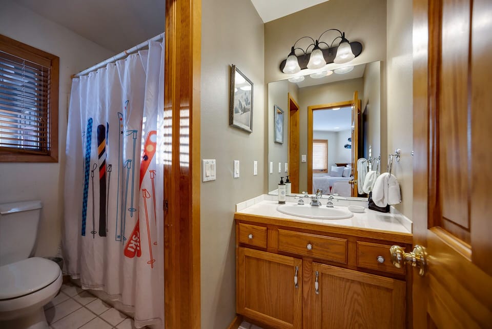 Freshen up in your bright bathroom with warm wood accents and ski-themed touches. Soft towels await after a day on the slopes.