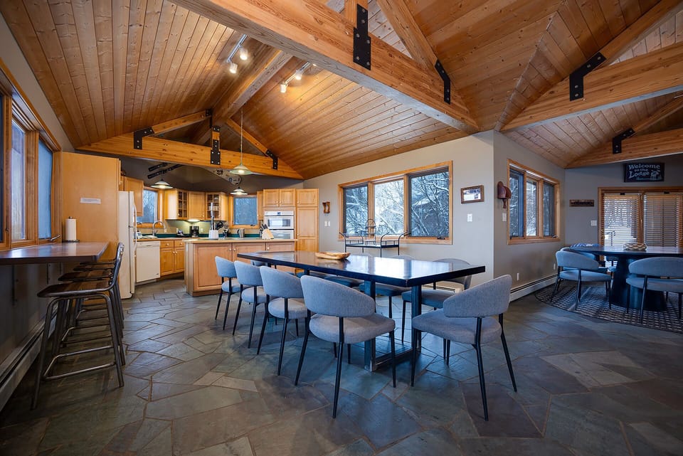 Gather around the spacious dining table under soaring wood beams, where your group can share meals and create memories together in this beautifully crafted mountain retreat.