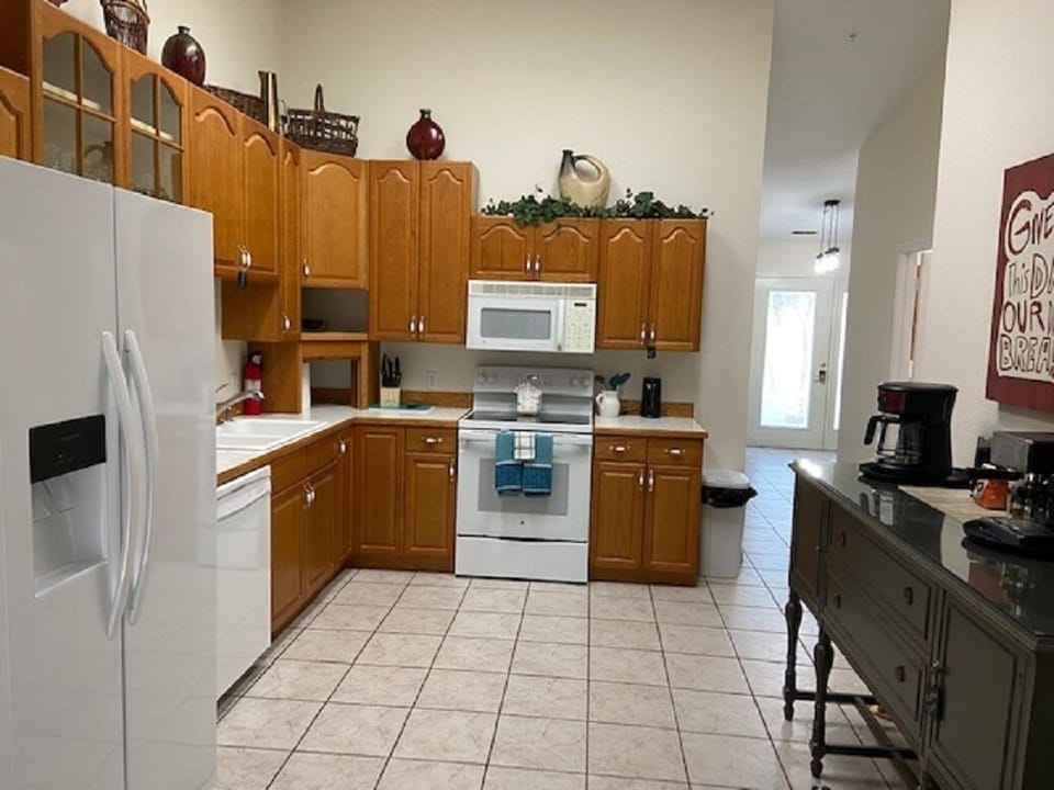 Large kitchen with new fridge and electric glass top stove.