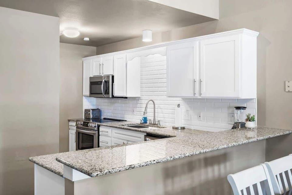 Kitchen with fully stocked cooking utensils and coffee bar. 